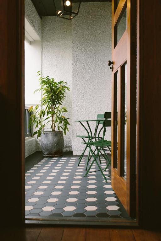 an open door to a patio with a table and a plant at The Convent Hotel in Auckland
