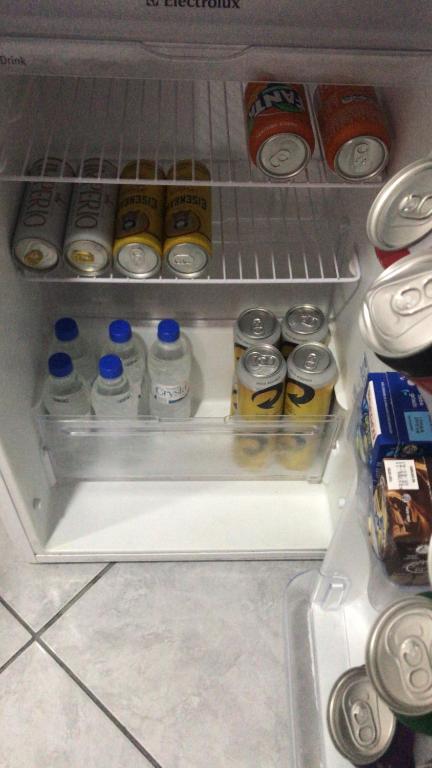 einen offenen Kühlschrank mit Getränken und Dosen Soda in der Unterkunft Quarto - Condomínio in Macapá