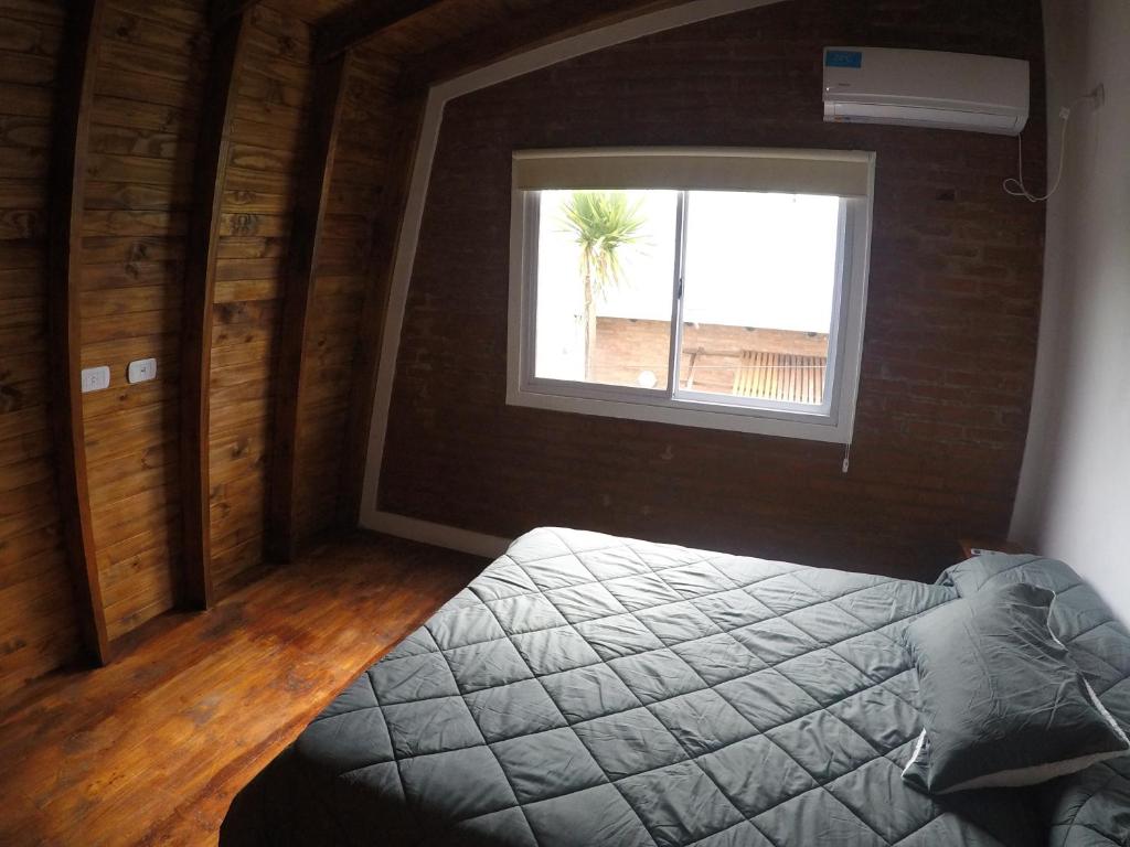 1 dormitorio con cama y ventana en Cabañas del Lagarto en Colón