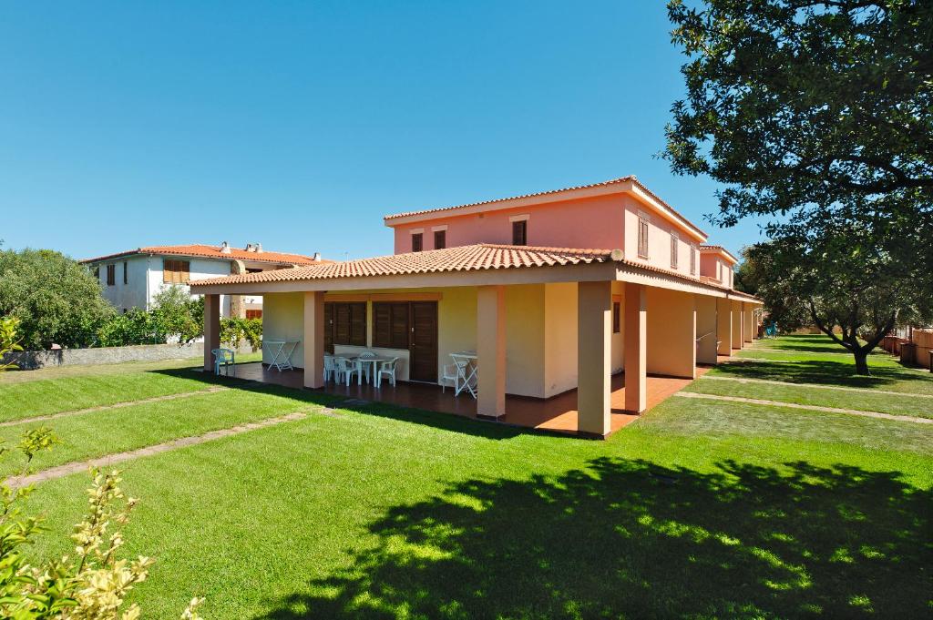 a house with a green lawn in front of it at Residence Li Menduli in San Teodoro