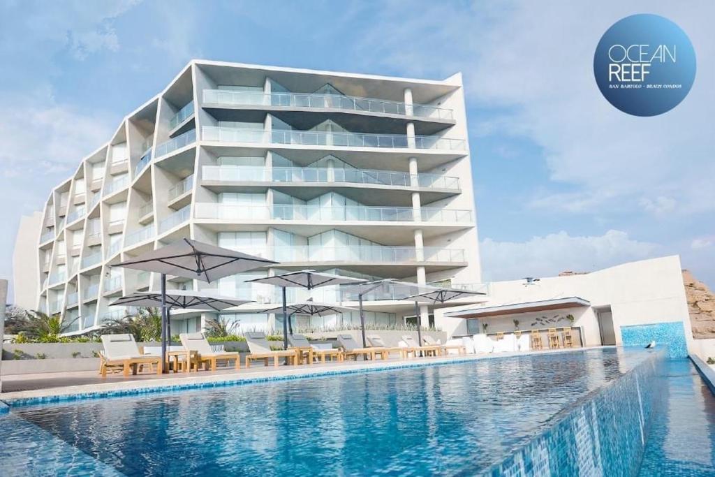 un hôtel avec une piscine en face d'un bâtiment dans l'établissement Vive - Descansa - Disfruta, à San Bartolo