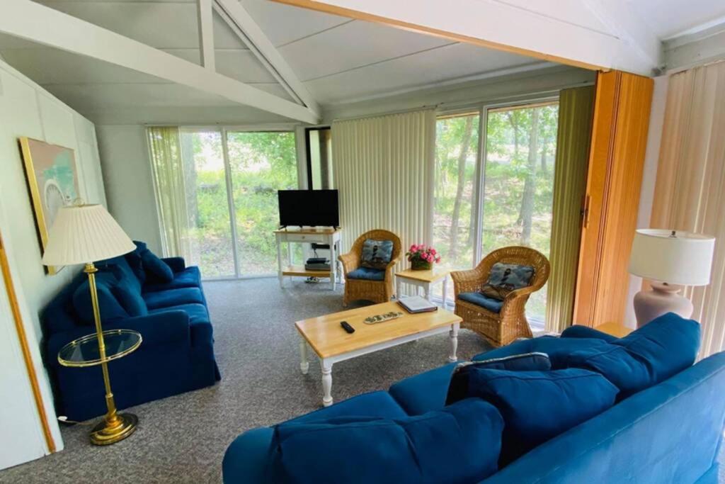 - un salon avec un canapé bleu et des chaises dans l'établissement Unit 8 - Treetop 2 Bedroom Villa, à Four Seasons