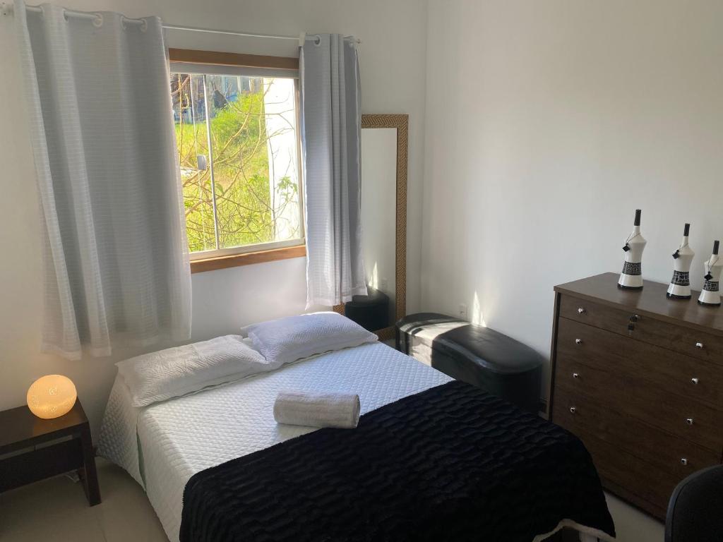 um quarto com uma cama e uma janela em Casa Jequitiba Quartos Mobiliados em Macaé