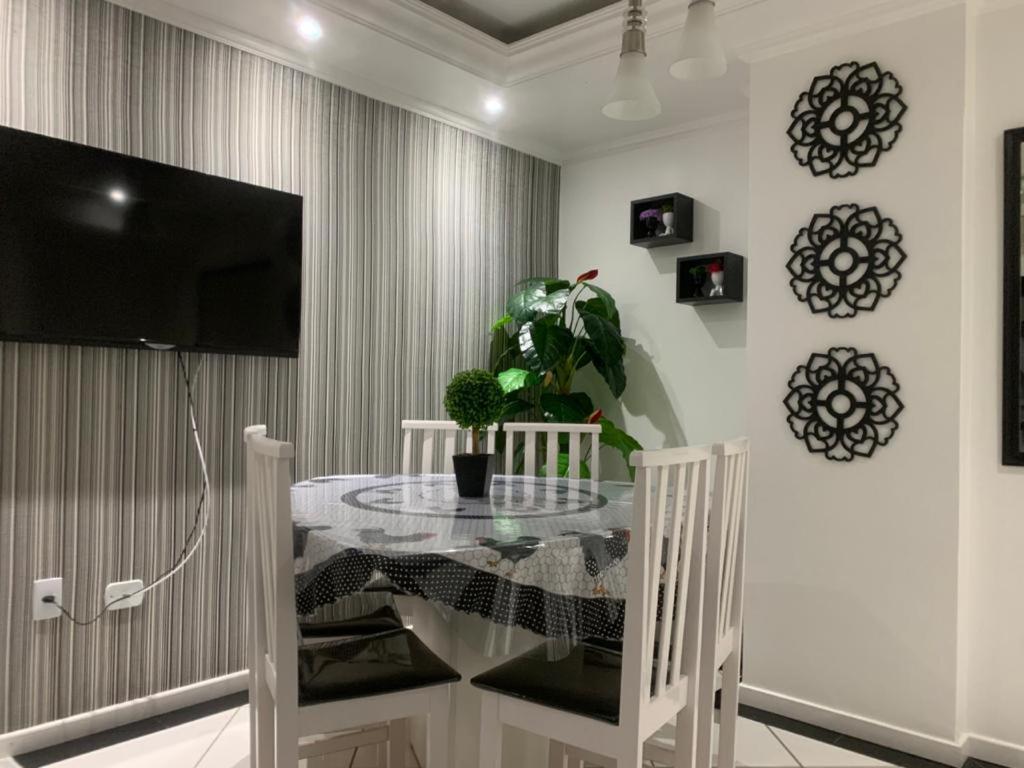 a dining room with a table and a tv at Apartamento Praia Central in Balneário Camboriú