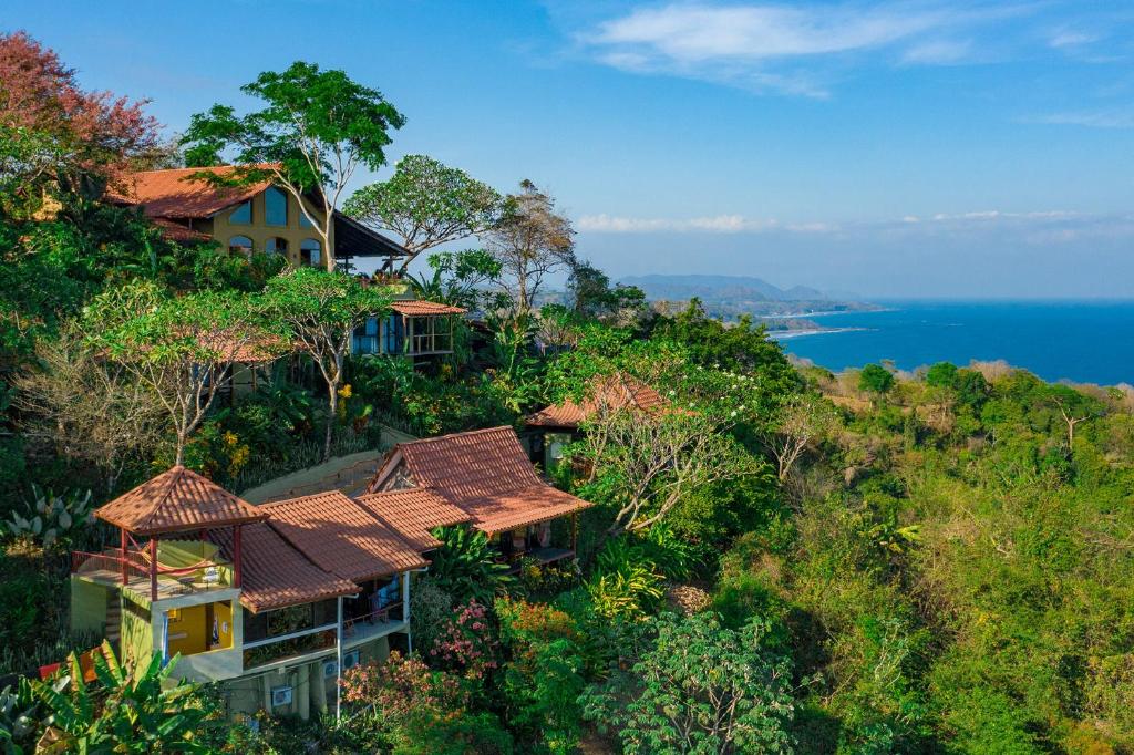 a house on top of a hill next to the ocean at Anamaya Resort in Montezuma