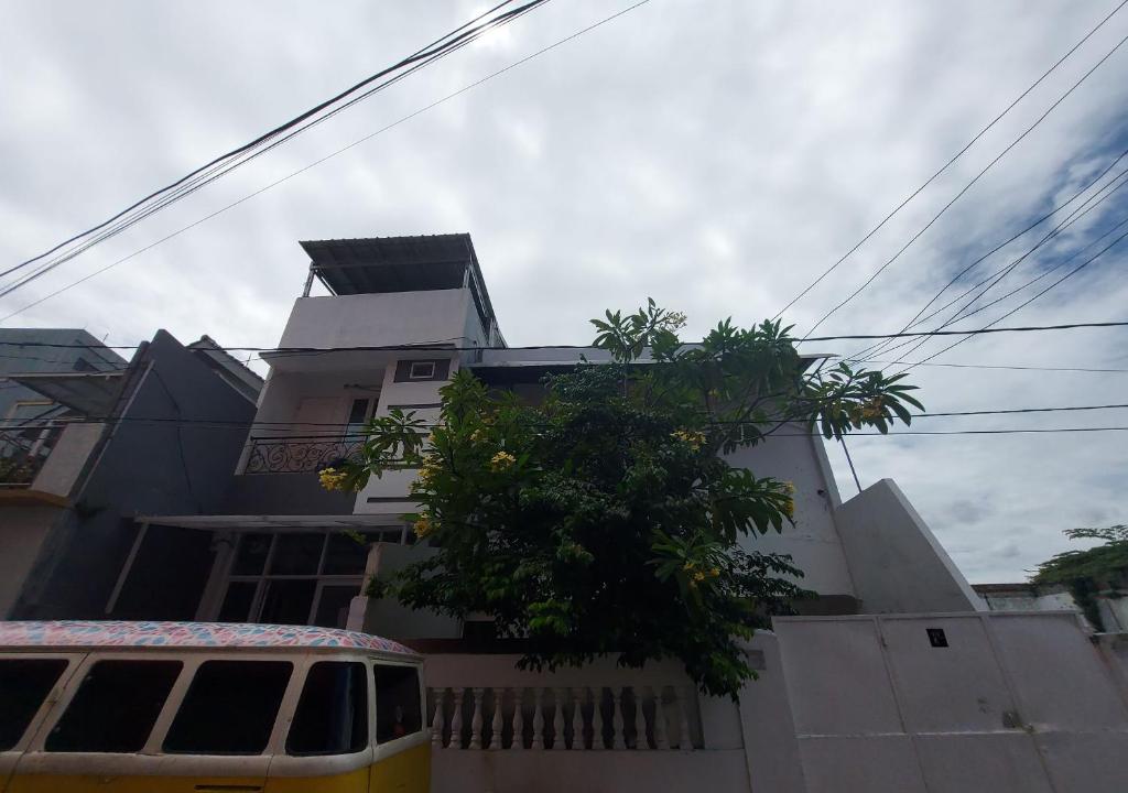 un autobus giallo parcheggiato di fronte a un edificio di Eiffel Residence Cideng - Female Only a Giacarta