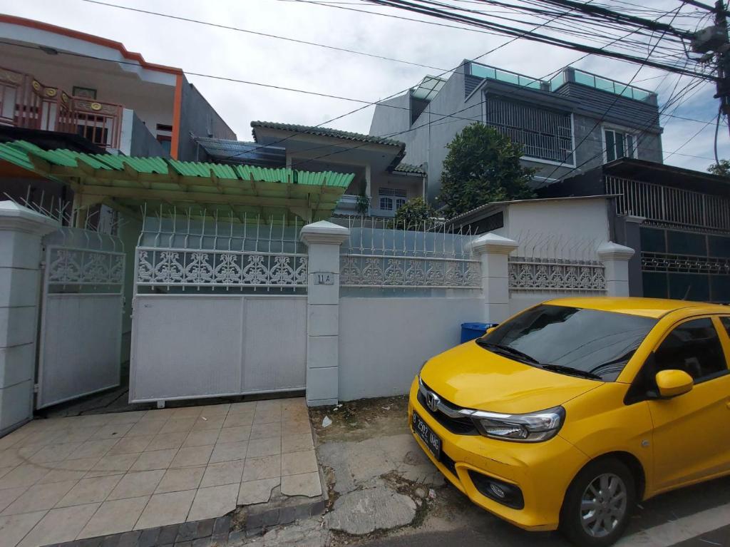 un coche amarillo estacionado frente a una casa en Eiffel Residence Tarakan - Female Only en Yakarta