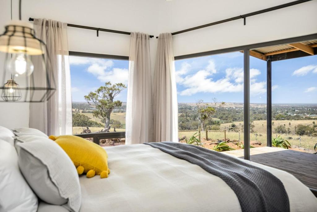 a bedroom with a bed and a large window at Old Bull Creek Luxury Retreat in Strathalbyn