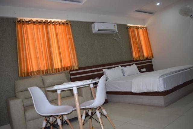 班加羅爾的住宿－hotel fortune suites，卧室配有一张床、一张桌子和椅子