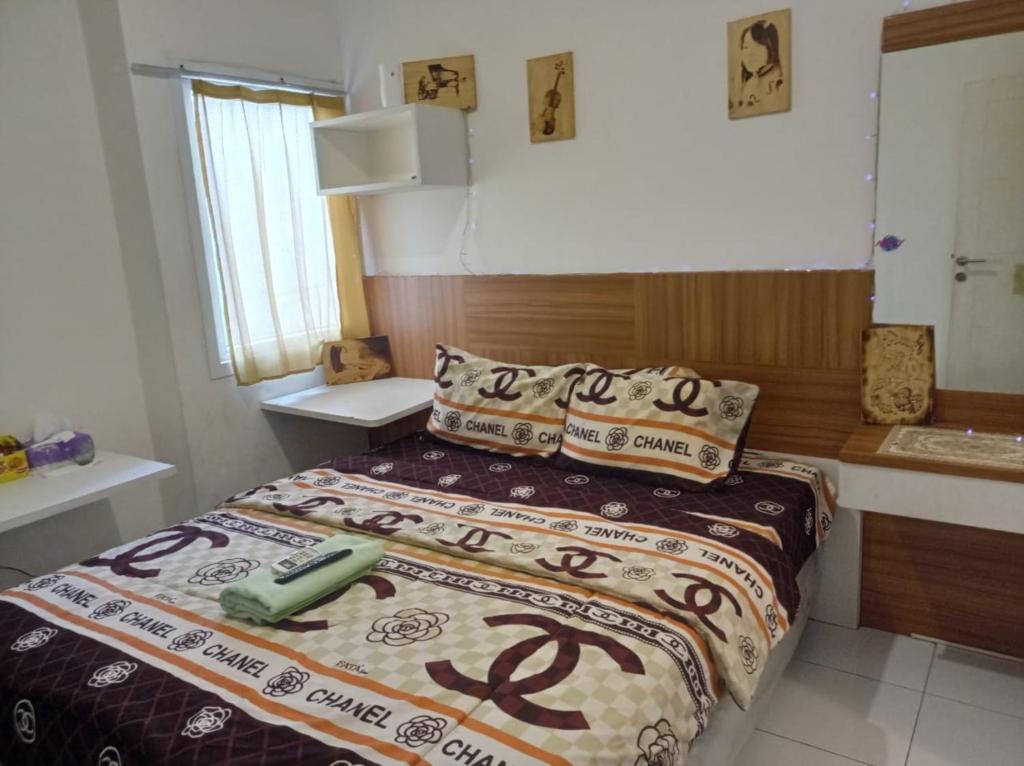 1 dormitorio con cama con edredón y almohadas en Bintang Property Aeropolis en Rawabambu