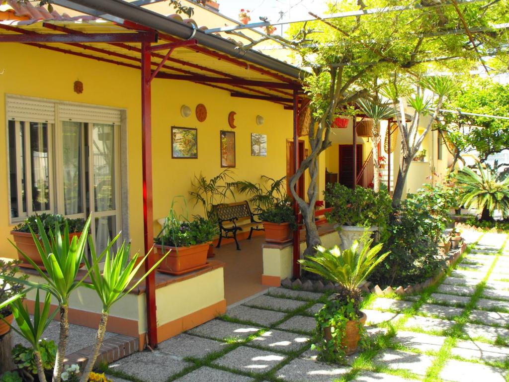 a yellow house with plants and a patio at Domus Felix in Ercolano
