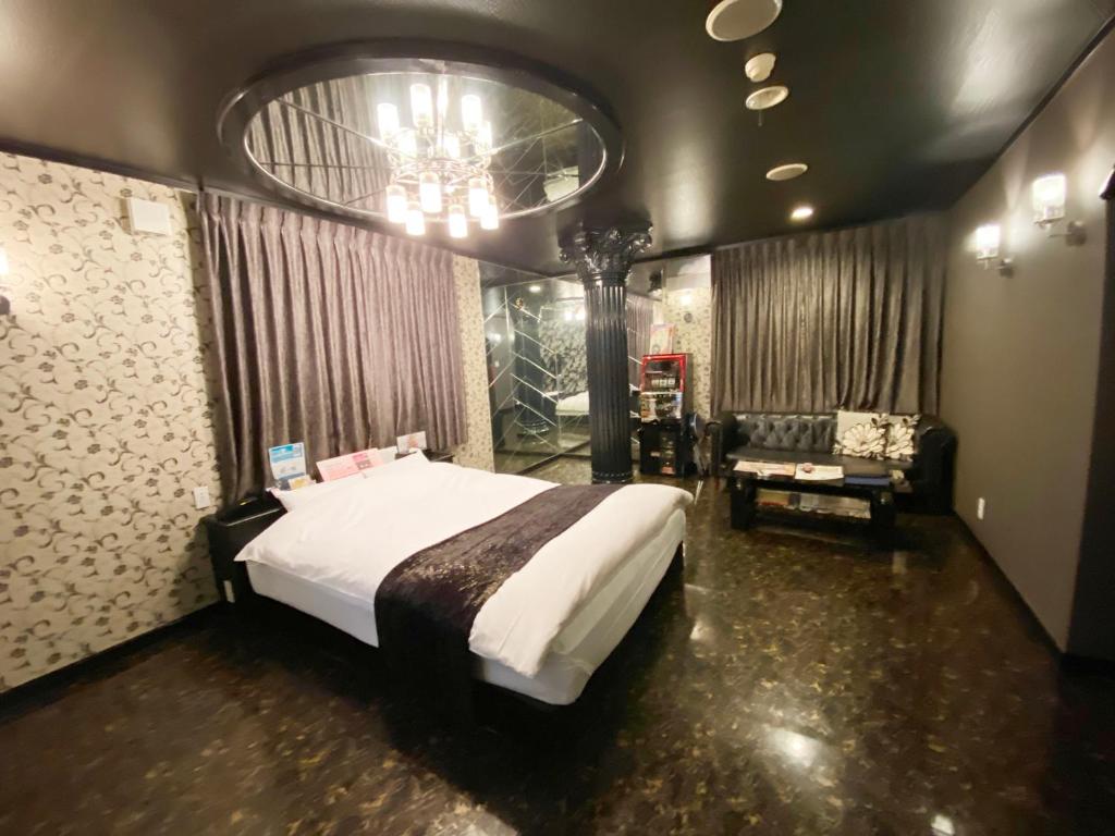 a bedroom with a large white bed and a couch at Wink in Saijo