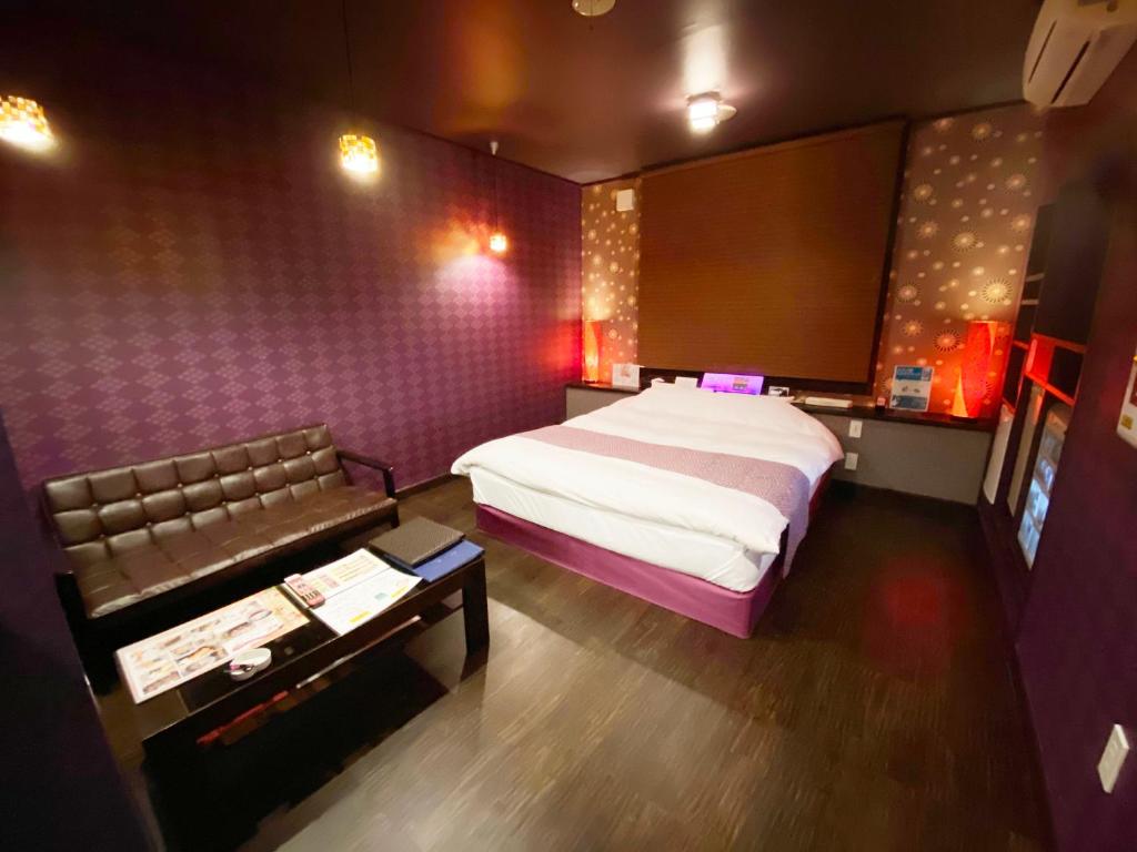 a bedroom with a large bed and a couch at Wink in Saijo