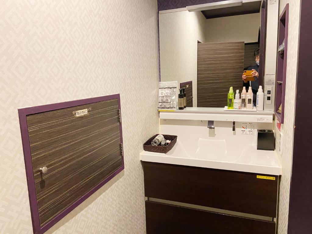 a bathroom with a sink and a mirror at Wink in Saijo