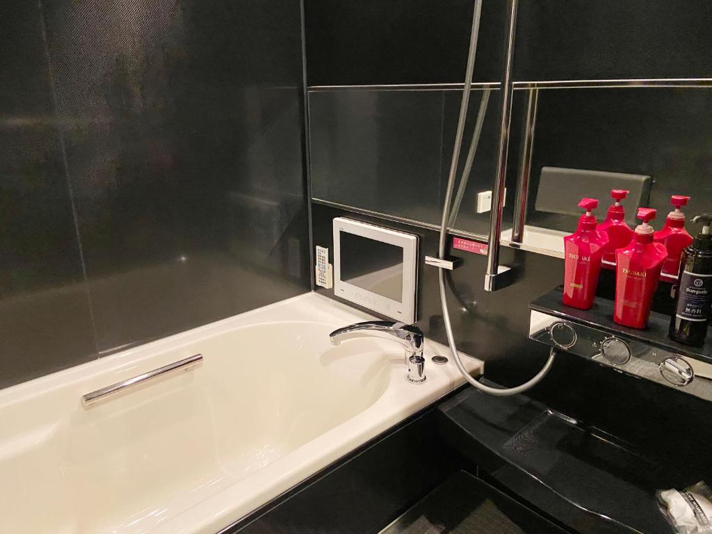 a bathroom with red bottles on a sink at Wink in Saijo