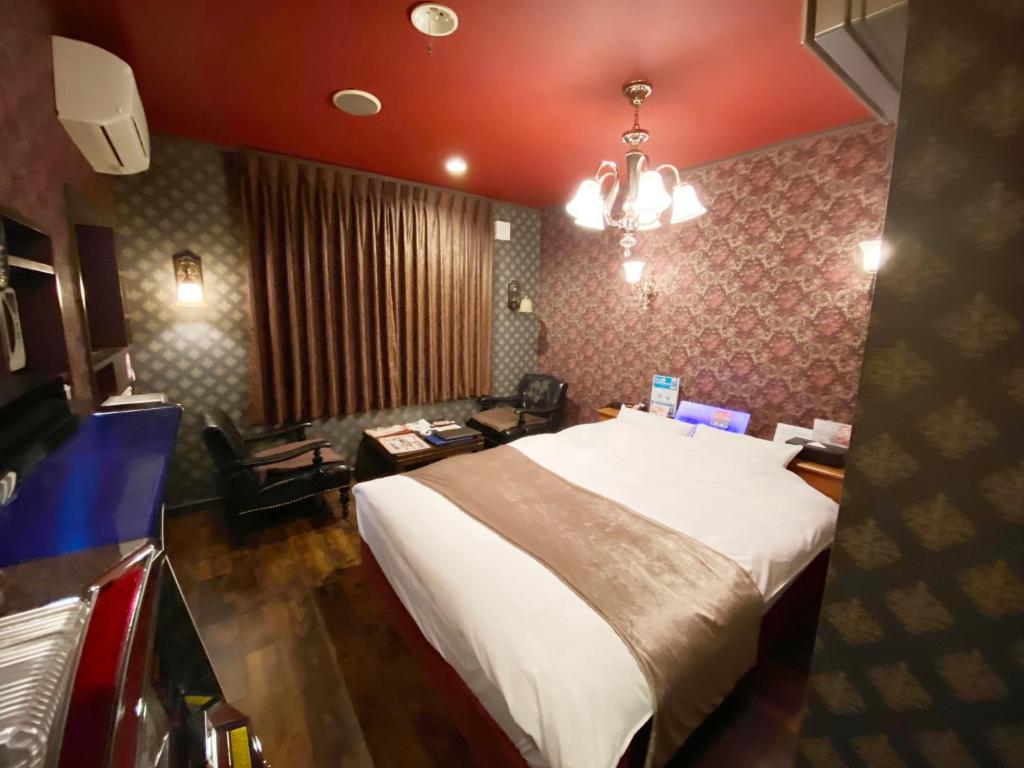 a bedroom with a large bed and a living room at Wink in Saijo