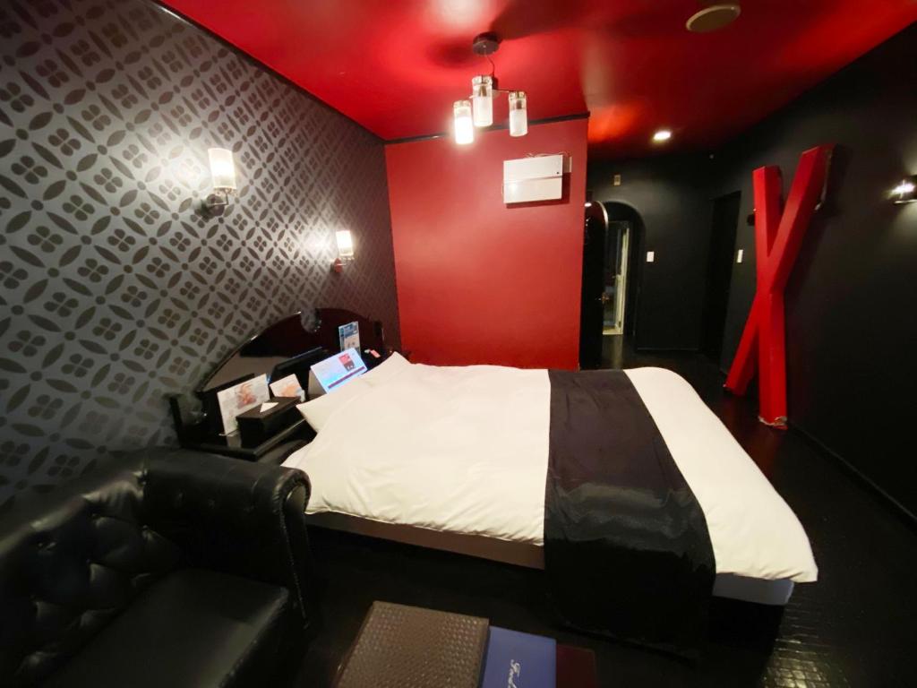 a bedroom with a bed and a red wall at Wink in Saijo