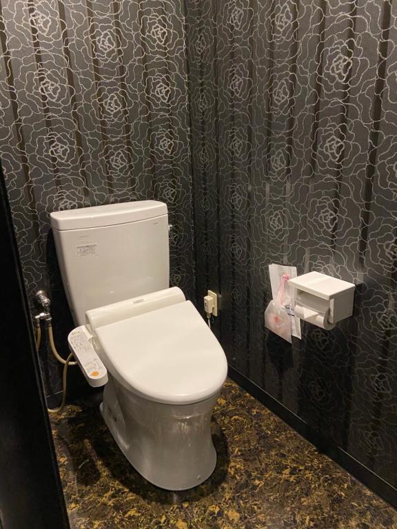 a bathroom with a white toilet in a stall at Wink in Saijo