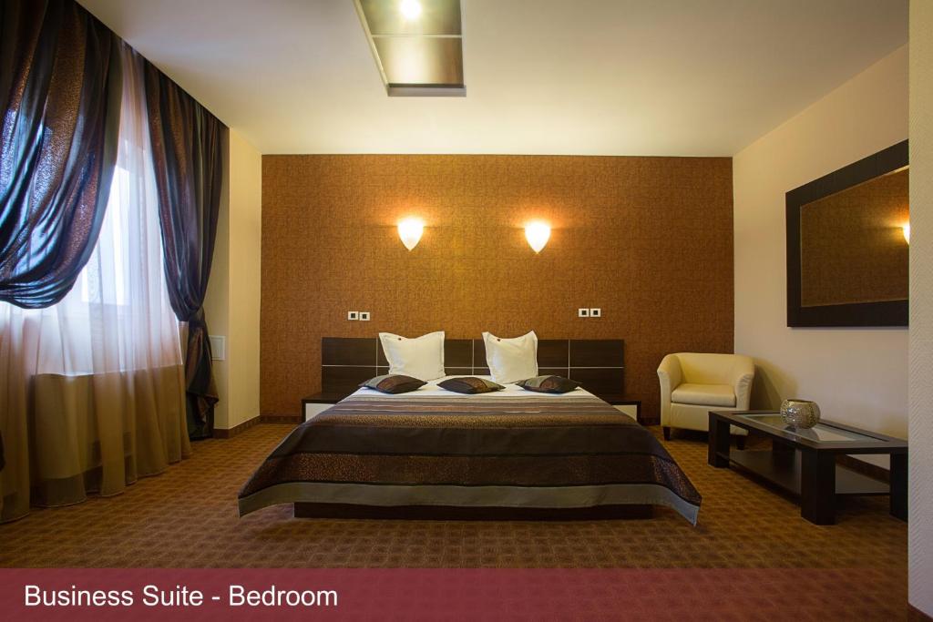 ブカレストにあるINTER BUSINESS Bucharestのベッドと椅子付きのホテルルーム