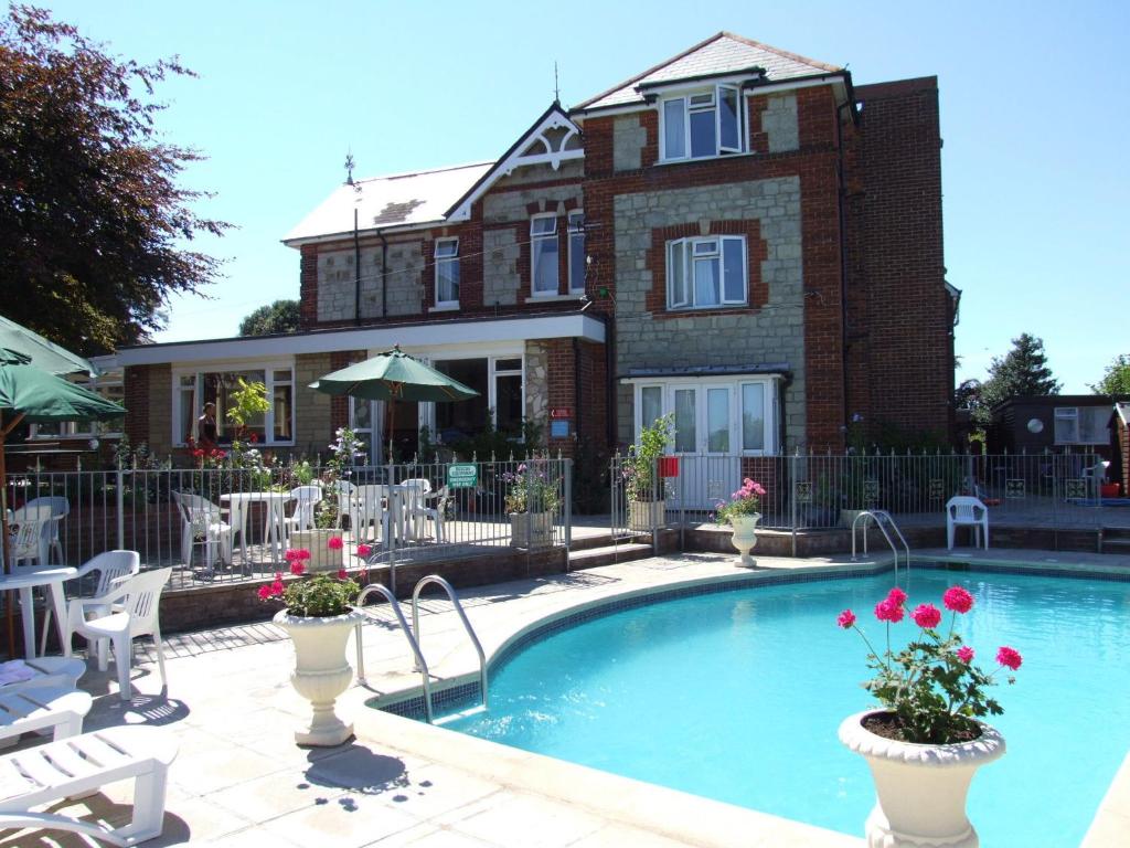 a swimming pool in front of a house at Eastmount Hall Hotel in Shanklin