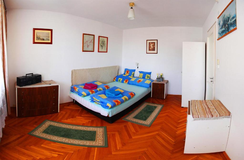 sypialnia z łóżkiem i drewnianą podłogą w obiekcie Óbuda Apartments w Budapeszcie