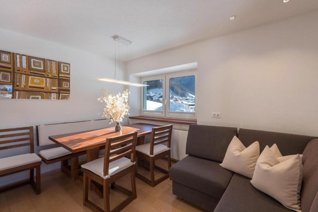 - une salle à manger avec un canapé et une table dans l'établissement Apartment Justine Wurdengeja, à Selva di Val Gardena