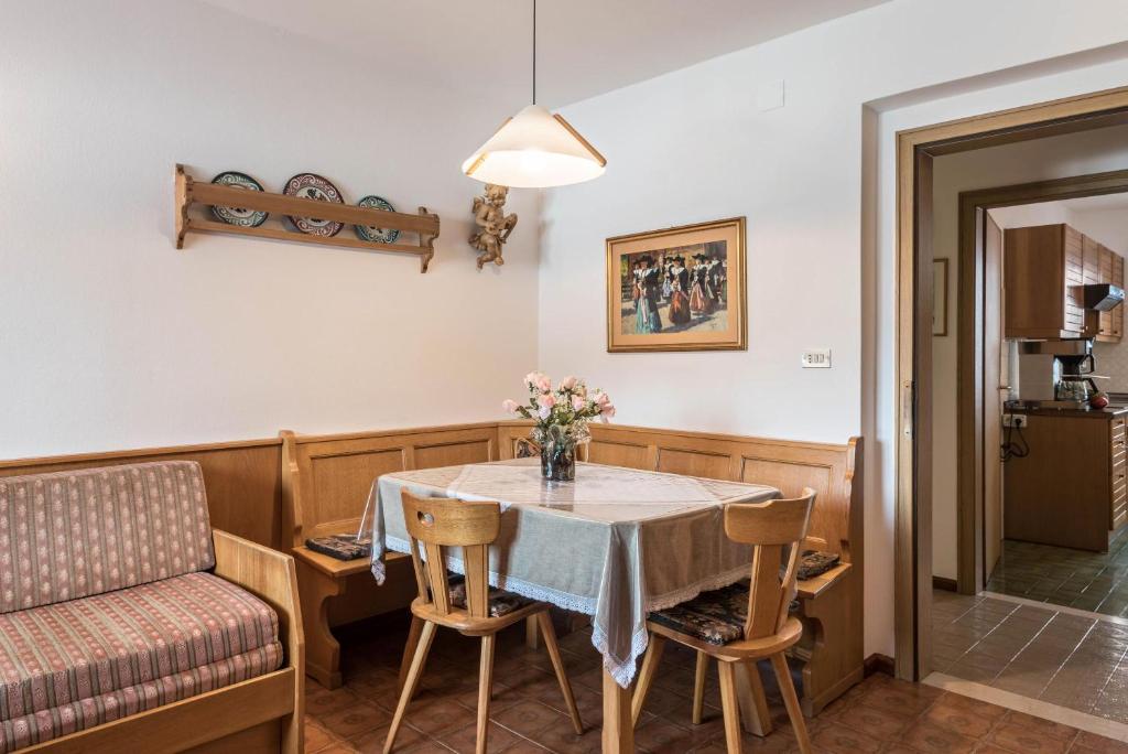 comedor con mesa y sillas en Große Gartenwohnung Haus Forelle, en Selva di Val Gardena
