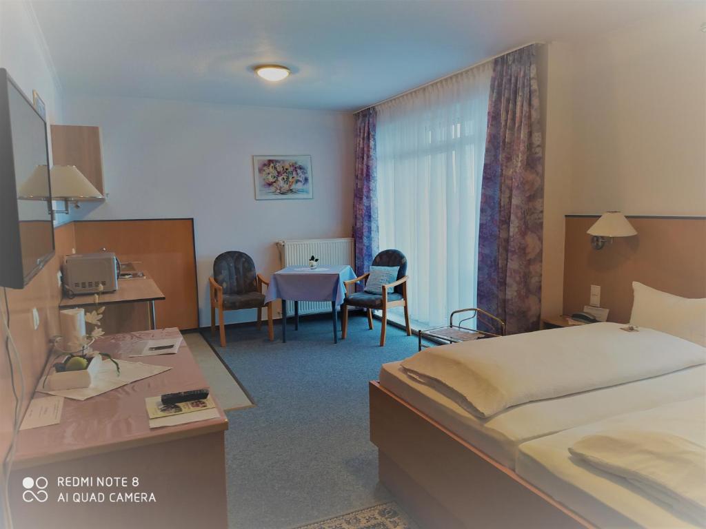 ein Hotelzimmer mit einem Bett und einem Tisch in der Unterkunft Hotel Diekgerdes Standard in Cloppenburg