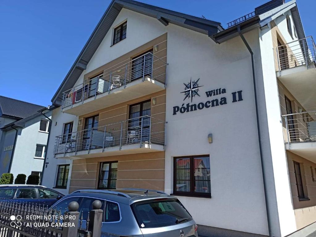 a building with a car parked in front of it at Willa Północna II in Karwia