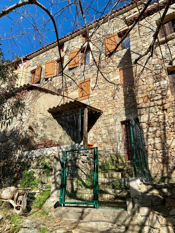 un bâtiment avec une porte verte devant lui dans l'établissement Charmante maison de village, à Arbori