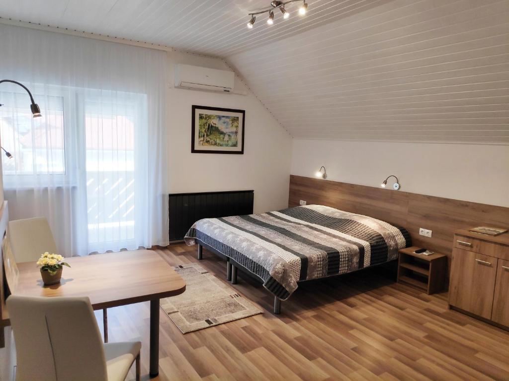 a bedroom with a bed and a table in it at Klára Villa Apartman in Hévíz