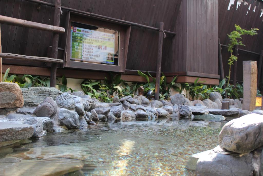 a pool of water with rocks in front of a building at Dormy Inn Akihabara in Tokyo