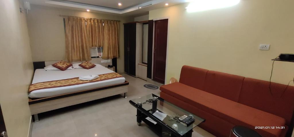 una camera d'albergo con letto e divano di Hotel Royal Residency a Siliguri