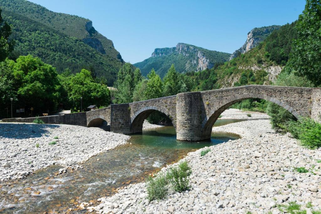a stone bridge over a river in the mountains at Hostal Almadiero in Burgui