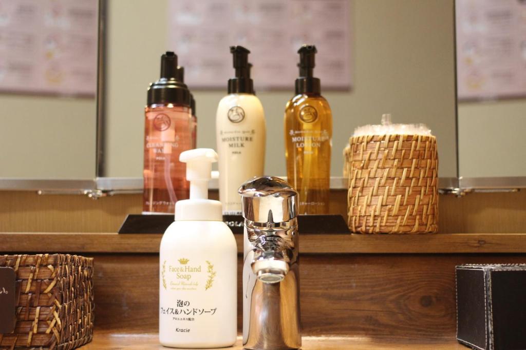 a counter with several bottles of soap and a dispenser at Dormy Inn Akihabara in Tokyo