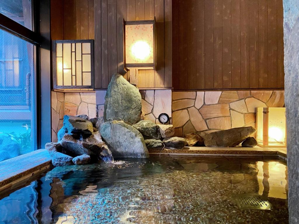 a swimming pool in a house with a water feature at Dormy Inn Akihabara in Tokyo