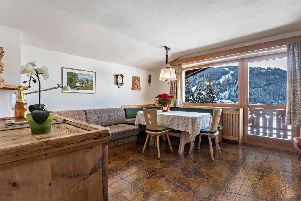 a living room with a table and a couch at Panoramico Haus Forelle in Selva di Val Gardena