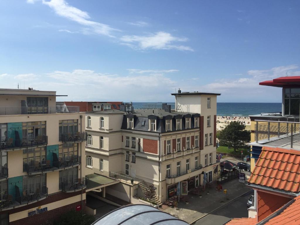 vistas a una ciudad con edificios y al océano en Ankerplatz Warnemünde - Direkte Strandnähe mit Leuchtturmblick en Warnemünde