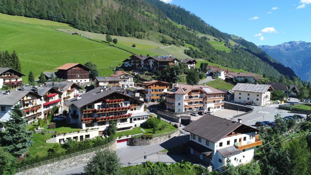 a village in the mountains with houses at Hotel Am Fels in Senales