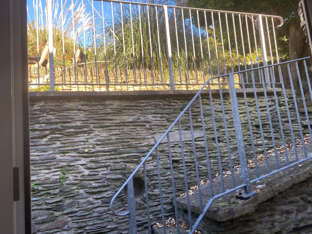 a metal railing on a walkway next to a river at Southover Beach in Woolacombe