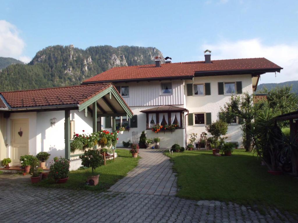 une grande maison blanche avec une allée en briques dans l'établissement Haus Schmauß - Chiemgau Karte, à Inzell