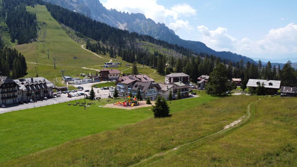 an aerial view of a resort in a green field at MyTime Hotels Savoy in Vigo di Fassa