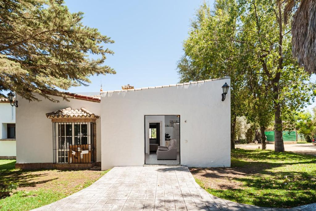 una casa blanca con una puerta en un patio en alojamiento rural la jandeta en Conil de la Frontera