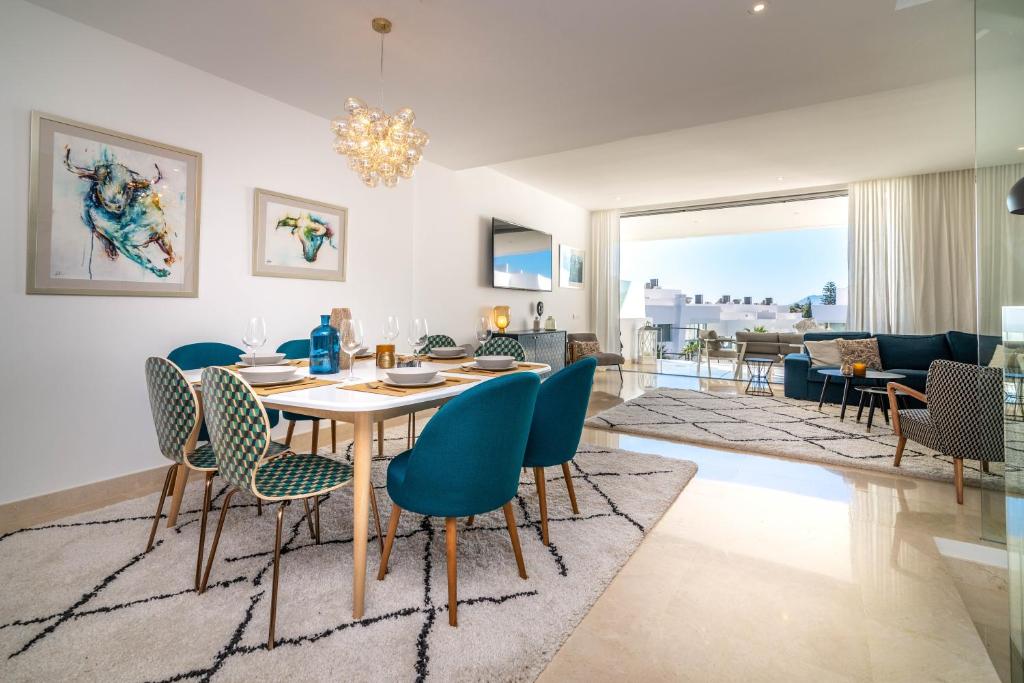 a dining room and living room with a table and chairs at VACATION MARBELLA I Casa Isabel, Private pool with infinity views, BBQ, New Built, Luxury Condo, Top Location in Marbella