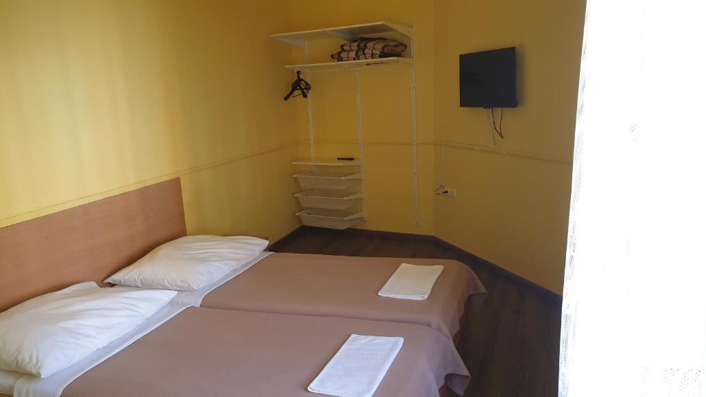 2 camas en una habitación pequeña con paredes amarillas en Jáde Panzió, en Budapest