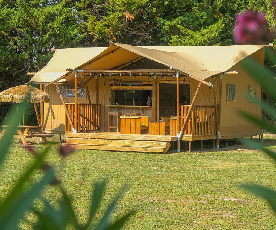 a large building with a tent in a yard at Lodge St Exupéry in Le Thor