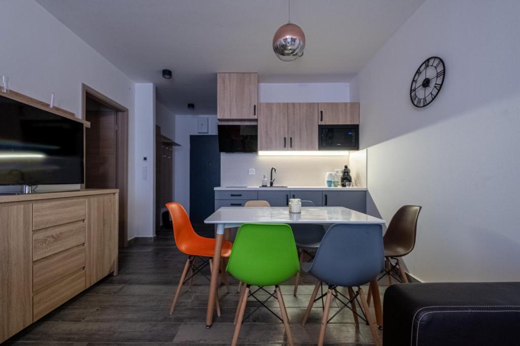 a kitchen and dining room with a table and chairs at Lido Riviera Sunshine Apartman Balatonlelle in Balatonlelle