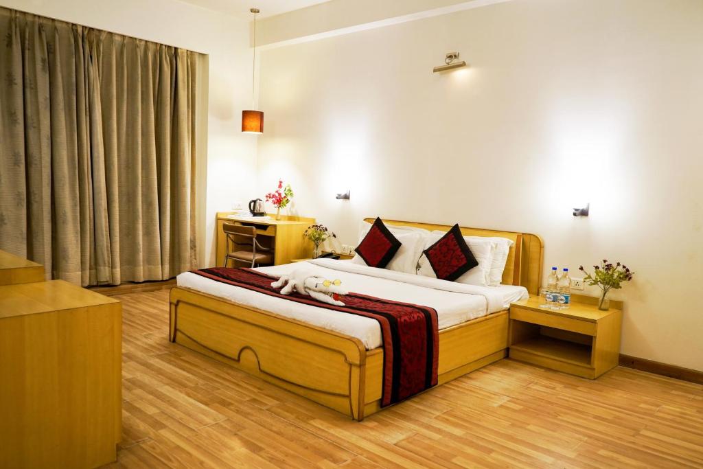 a bedroom with a large bed in a room at Hotel Adityaz in Gwalior