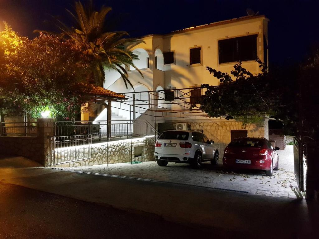 due auto parcheggiate di notte davanti a un edificio di Apartments Vila Tisa a Mali Lošinj (Lussinpiccolo)