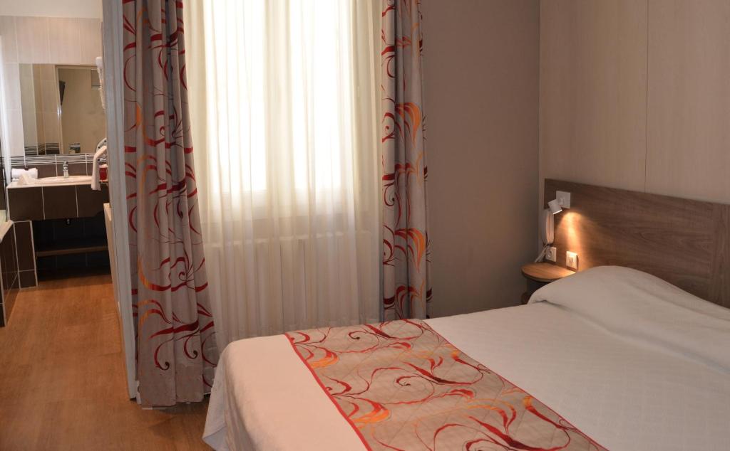 Postel nebo postele na pokoji v ubytování Brit Hotel Confort Le Revest Sainte-Maxime